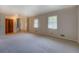 Spacious living room with carpet flooring, two windows, and a glimpse of the staircase at 2198 Kings Forest Se Dr, Conyers, GA 30013