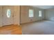 Bright living room features carpeted flooring, two windows, and a view of the home's front door at 2198 Kings Forest Se Dr, Conyers, GA 30013