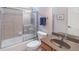 Bathroom featuring a shower-tub combo with glass doors and single sink at 3853 Coralberry Ct, Dacula, GA 30019