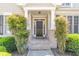 Inviting front entrance featuring a black door, brick accents, and manicured shrubs at 3853 Coralberry Ct, Dacula, GA 30019
