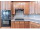 A close-up of kitchen featuring wood cabinets and modern black appliances at 3853 Coralberry Ct, Dacula, GA 30019