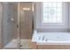 Bright bathroom with a large glass shower and a soaking tub at 3853 Coralberry Ct, Dacula, GA 30019