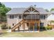 Rear exterior view of home featuring a screened porch, wood deck, and a spacious backyard at 3853 Coralberry Ct, Dacula, GA 30019