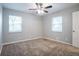 Neutral bedroom features carpet, a ceiling fan, and two large windows at 3905 Kirksford Dr, Decatur, GA 30035