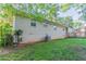 View of the exterior showing the large, grassy lawn, brick siding, and central AC unit at 3905 Kirksford Dr, Decatur, GA 30035
