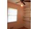 Bedroom with neutral walls, window, ceiling fan, and built-in shelving at 8317 Marlborough Dr, Jonesboro, GA 30238