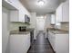 Well-lit kitchen with granite countertops, stainless appliances, white cabinets, and dark wood floors at 2800 Macon Se Dr, Atlanta, GA 30354