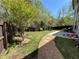 A spacious backyard with a privacy fence, featuring a stone path, lush lawn and plenty of room for activities at 2964 Olivine Dr, Dacula, GA 30019