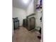 Tiled laundry room featuring modern washer and dryer, ample cabinet space, and organized shelving at 2964 Olivine Dr, Dacula, GA 30019