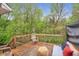 A cozy outdoor deck with wooden furniture and a peaceful view of lush greenery at 4917 Baker Ridge Pl, Acworth, GA 30101