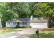 Charming home featuring a two-car garage and a beautifully maintained front yard with mature trees at 5819 Stonehaven Nw Dr, Kennesaw, GA 30152