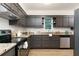 Modern kitchen featuring dark cabinetry, stainless steel appliances, and granite countertops at 5819 Stonehaven Nw Dr, Kennesaw, GA 30152