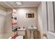 Cozy bathroom featuring a vintage pedestal sink, a toilet, and a tub with a colorful shower curtain at 8100 Greens Mill Way, Loganville, GA 30052