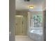 Bright bathroom featuring tiled floors, a glass-door shower, and a corner soaking tub at 8100 Greens Mill Way, Loganville, GA 30052
