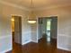 Open dining area features hardwood flooring, classic molding, and transitions to other spaces at 8100 Greens Mill Way, Loganville, GA 30052