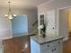 Bright kitchen island with granite counters, white cabinets, and a view into the breakfast room at 8100 Greens Mill Way, Loganville, GA 30052