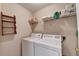 Bright laundry room with washer, dryer, and storage shelves at 8100 Greens Mill Way, Loganville, GA 30052