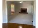 Carpeted living room with fireplace, ceiling fan, and hardwood flooring in adjacent room at 8100 Greens Mill Way, Loganville, GA 30052