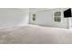 Spacious bedroom with neutral carpet, tray ceiling, and bright natural light from large windows at 104 Marlow Dr, Woodstock, GA 30188