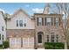 Charming two-story home features a brick and siding exterior, a two-car garage and manicured landscaping at 104 Marlow Dr, Woodstock, GA 30188