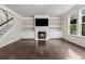 Bright living room with hardwood floors, fireplace, built-in shelves, and large windows at 104 Marlow Dr, Woodstock, GA 30188