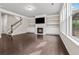 Bright living room with hardwood floors, fireplace, built-in shelves, and staircase at 104 Marlow Dr, Woodstock, GA 30188