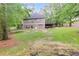 Backyard view featuring a house, lawn, deck, and mature trees, providing a serene outdoor space at 1058 Magnolia Dr, Villa Rica, GA 30180