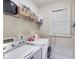 Bright laundry room with white washer and dryer, overhead shelving, and a window for natural light at 1058 Magnolia Dr, Villa Rica, GA 30180