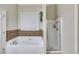 Bright bathroom with a separate tub, a glass shower, and neutral tile finishes at 1058 Magnolia Dr, Villa Rica, GA 30180