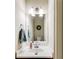 Cozy powder room featuring a single vanity, decorative mirror, and elegant lighting fixtures at 1058 Magnolia Dr, Villa Rica, GA 30180