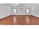Bright living room featuring hardwood floors, white walls, and natural light from two windows at 5589 Dendy Trc, Fairburn, GA 30213