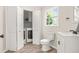 Well-lit bathroom featuring a vanity, toilet, and laundry area behind folding doors at 750 Southland Pass, Stone Mountain, GA 30087