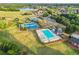 Aerial view of the community pool, tennis courts, and playground in a well-maintained neighborhood with green lawns at 750 Southland Pass, Stone Mountain, GA 30087