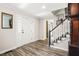 Inviting foyer featuring wood-look floors, white trim, and a classic staircase with white spindles and a dark handrail at 750 Southland Pass, Stone Mountain, GA 30087