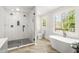 Gorgeous bathroom featuring a large glass shower, soaking tub, wood look tile floors and bright windows at 750 Southland Pass, Stone Mountain, GA 30087