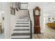 Staircase leading to the second floor, complete with a grandfather clock, and wood-look flooring at 750 Southland Pass, Stone Mountain, GA 30087