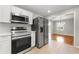 Open concept kitchen showcasing stainless steel appliances, white cabinets, and a view to dining room at 2461 Antwerp Se Dr, Atlanta, GA 30315