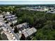 Aerial view of townhomes with trees, highway, and sunny sky with trees. Community and cityscape at 2928 Wintercrest Way, Atlanta, GA 30360