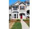 Charming townhome featuring a red front door, bay window, and well-maintained landscaping at 73 Timber Ridge Dr, Cartersville, GA 30121