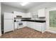 Bright kitchen equipped with white appliances, contrasting countertops, and convenient access to the backyard at 73 Timber Ridge Dr, Cartersville, GA 30121