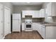 Clean kitchen featuring white appliances, white cabinets, and neutral countertops at 73 Timber Ridge Dr, Cartersville, GA 30121