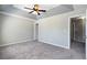 The main bedroom features a tray ceiling with fan, plush carpet, and access to other rooms at 73 Timber Ridge Dr, Cartersville, GA 30121