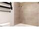 Bathtub-shower combo with light grey tile, black fixtures and granite countertop at 1110 Bakary Ct, Decatur, GA 30032