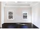 Bright bedroom with dark wood floors, two windows, and tray ceiling with recessed lighting at 1110 Bakary Ct, Decatur, GA 30032