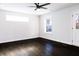 Spacious bedroom with dark wood floors, ceiling fan, and ample natural light from windows at 1110 Bakary Ct, Decatur, GA 30032