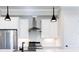 Close up of modern kitchen with stainless steel appliances and range hood, and white herringbone backsplash at 1110 Bakary Ct, Decatur, GA 30032