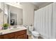 Neutral-toned bathroom featuring a framed mirror, wooden cabinets, and a patterned shower curtain at 1647 Sabastian Ne Pt, Atlanta, GA 30329