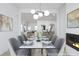Elegant dining room with modern lighting, a fireplace, and an open view to the kitchen and living areas at 3353 Hemphill St, Atlanta, GA 30337