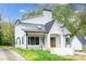 Elegant white farmhouse with a black metal roof, skylights, and a welcoming front porch at 3353 Hemphill St, Atlanta, GA 30337
