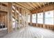View of an unfinished living room framed with wood and many windows filling the space with natural light at 3353 Hemphill St, Atlanta, GA 30337